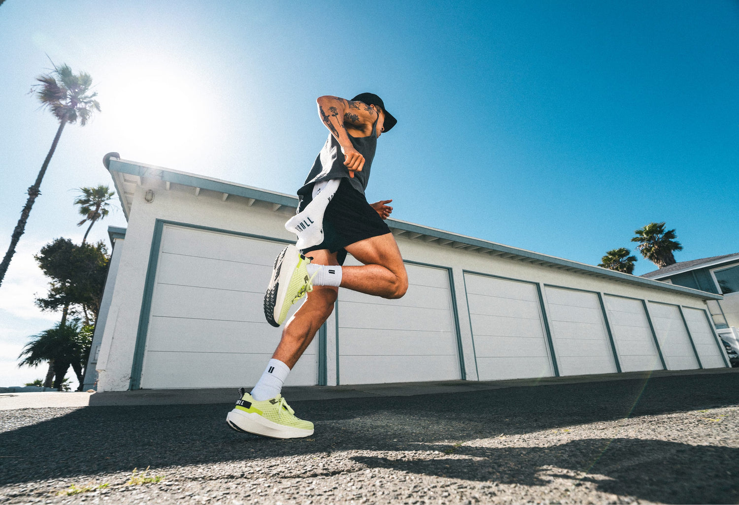Person running outdoors with palm trees and a clear sky in the background